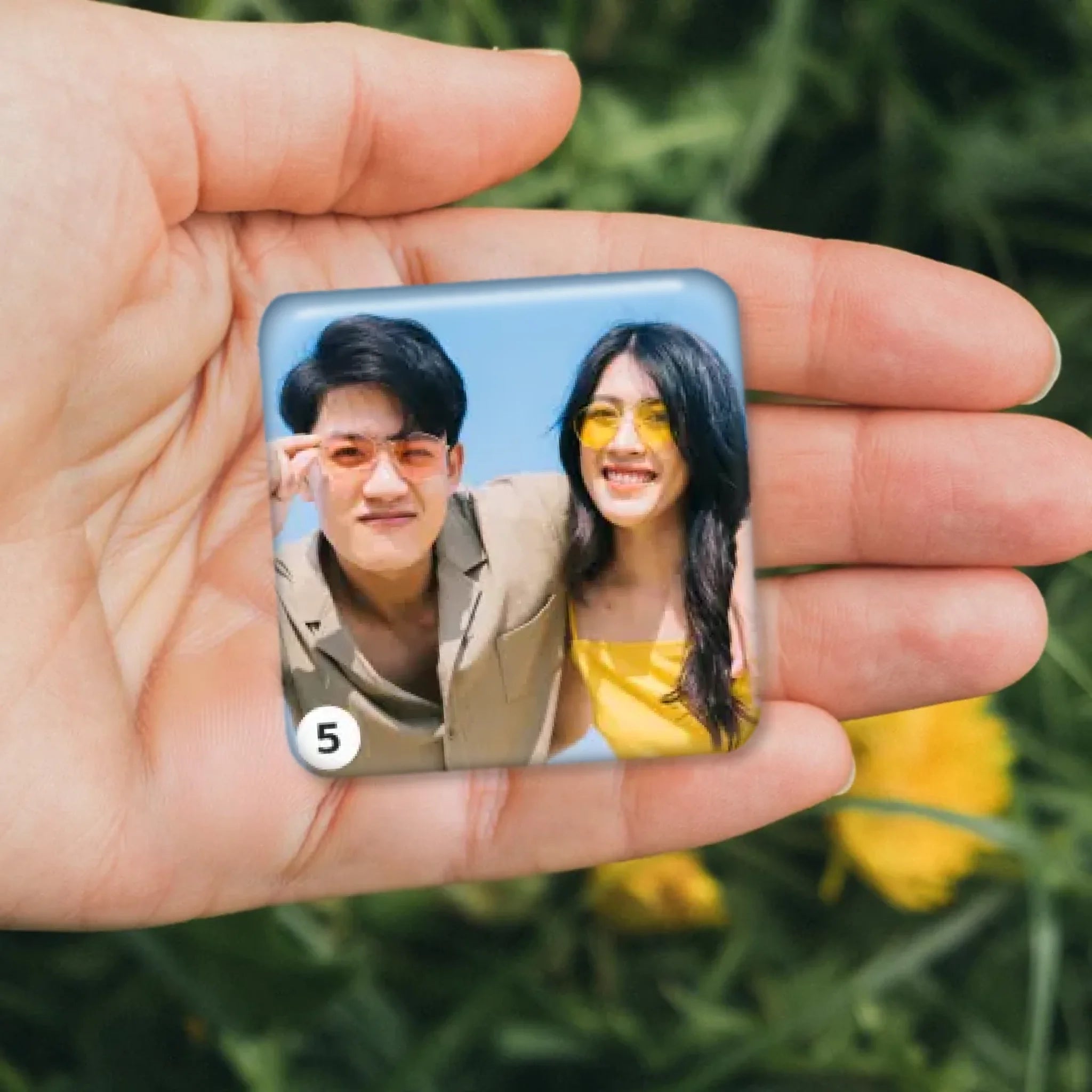 รูปภาพ แม่เหล็กติดตู้เย็น วางอยู่บนมือ